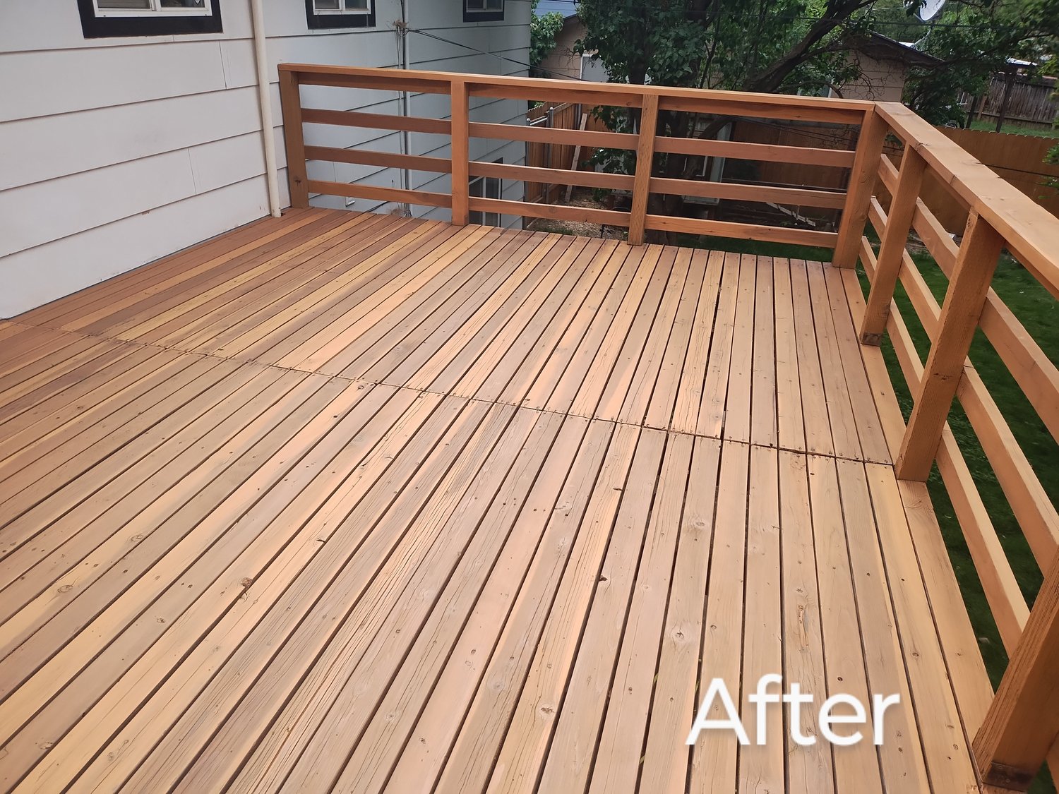 Newly stained wooden deck patio attached to a modern home